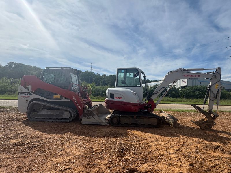 Takeuchi TB240 mini excavator and Takeuchi TL10V2 compact track loader side by side with heavy duty replacement rubber tracks installed