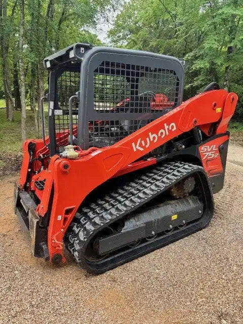 Orange Kubota compact track loader with a caged operator cabin.