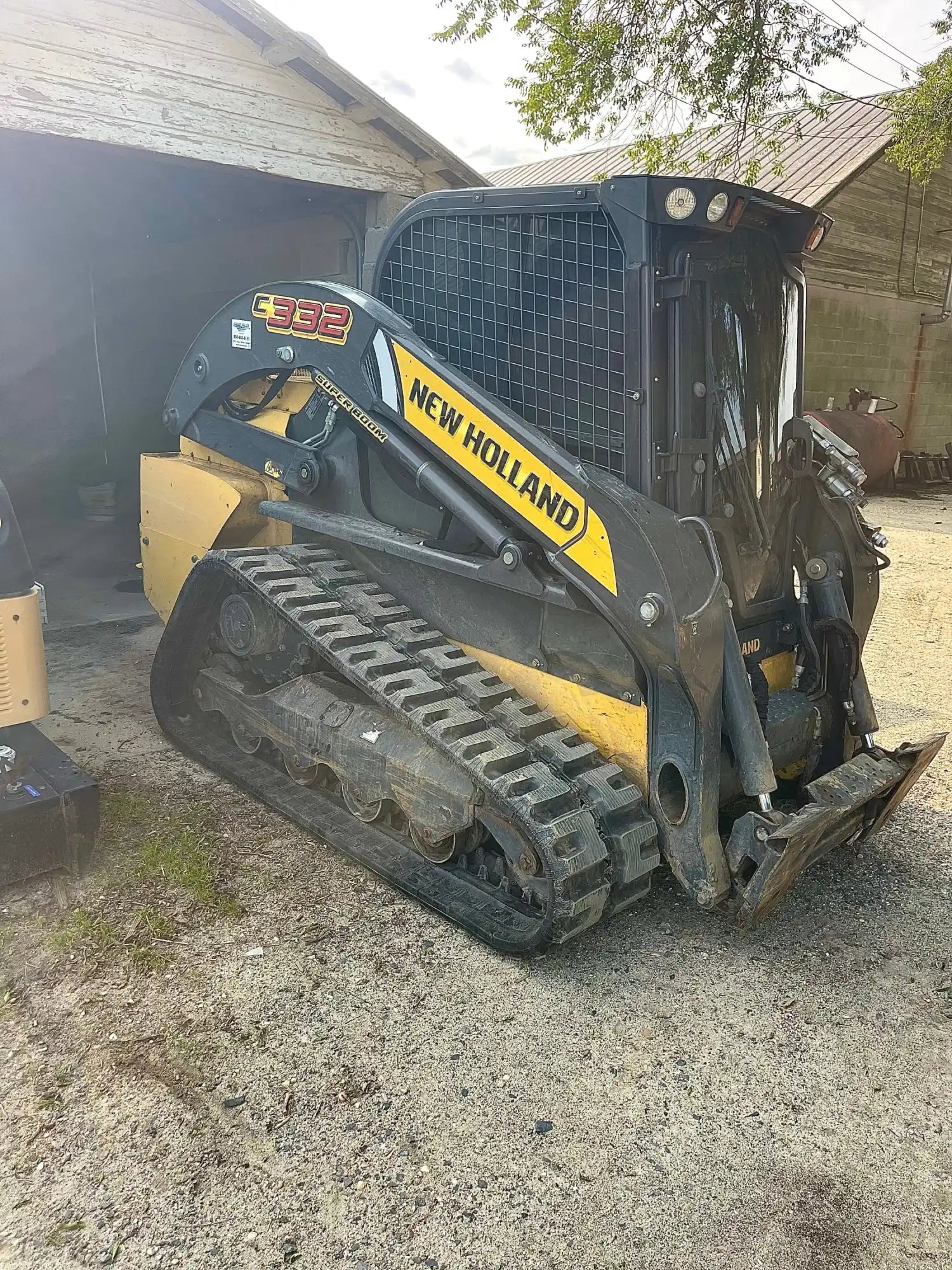 Yellow and black compact track loader with rubber tracks.