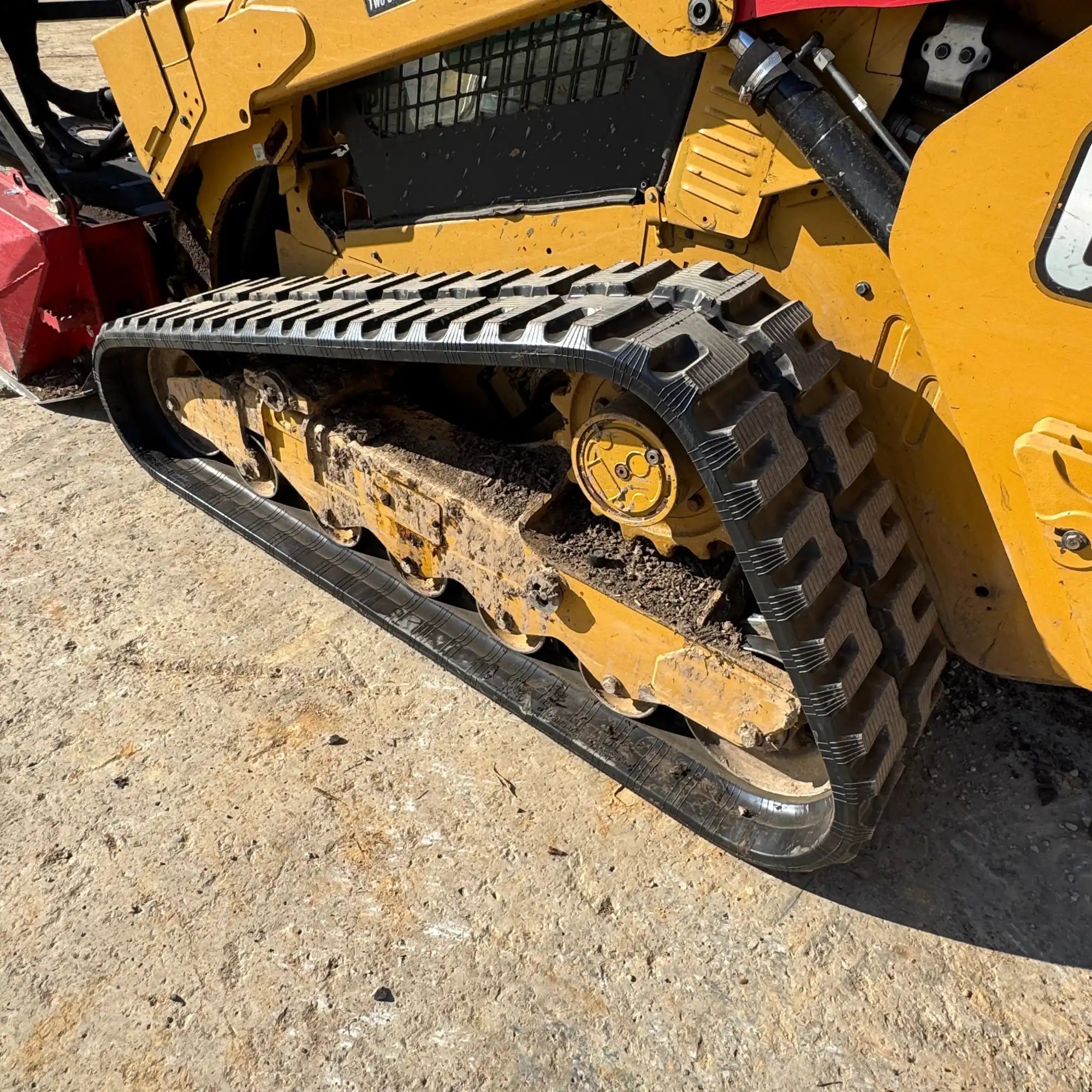 Yellow compact track loader with rubber tracks