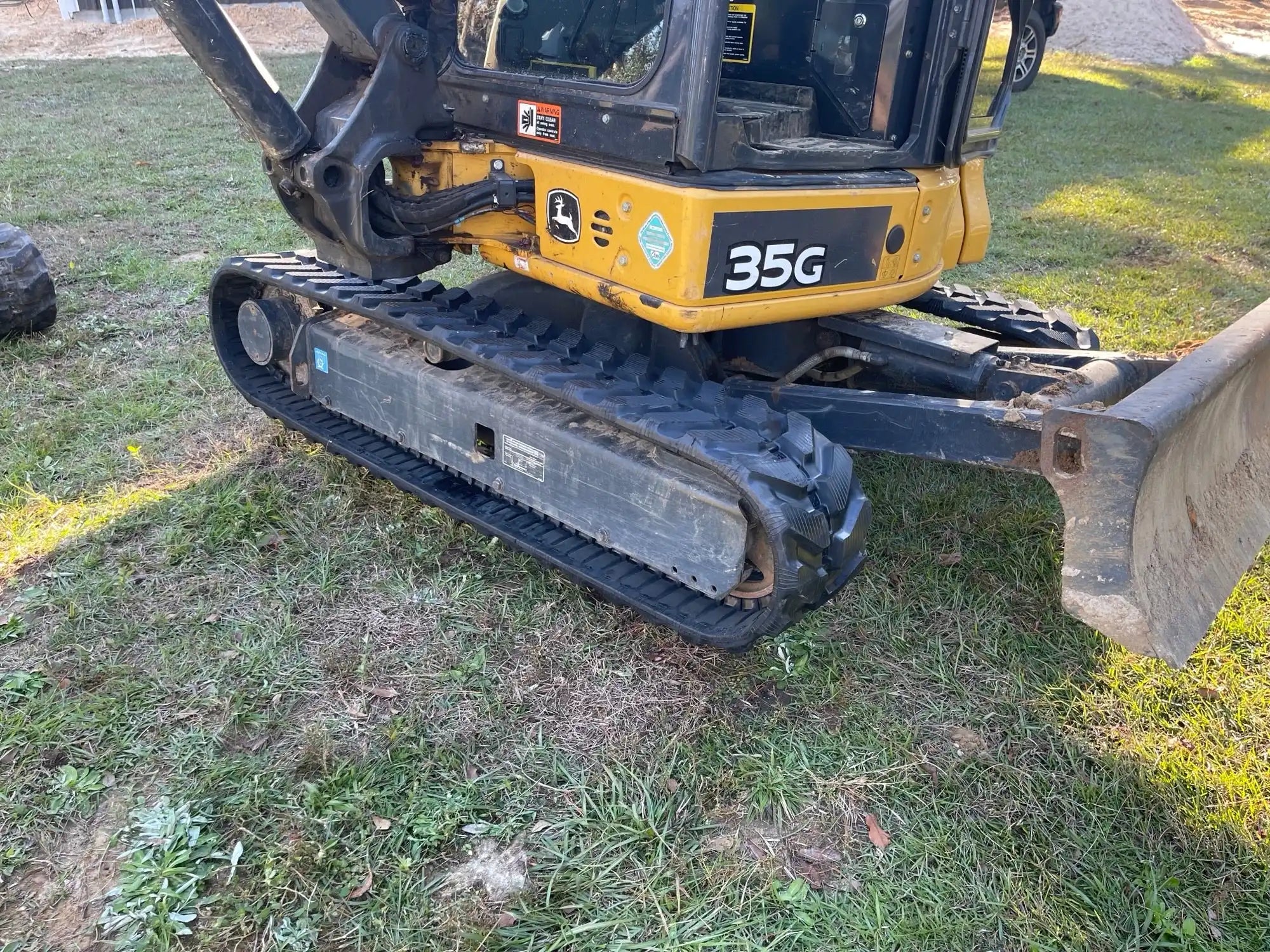 Small excavator labeled '35G' on a grassy area